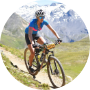 A man wearing a helmet and sports clothes is riding a bicycle in the mountans