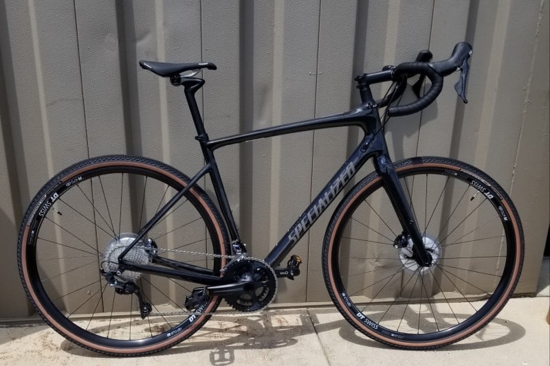 A black fitness bikes is standing near the metal fence