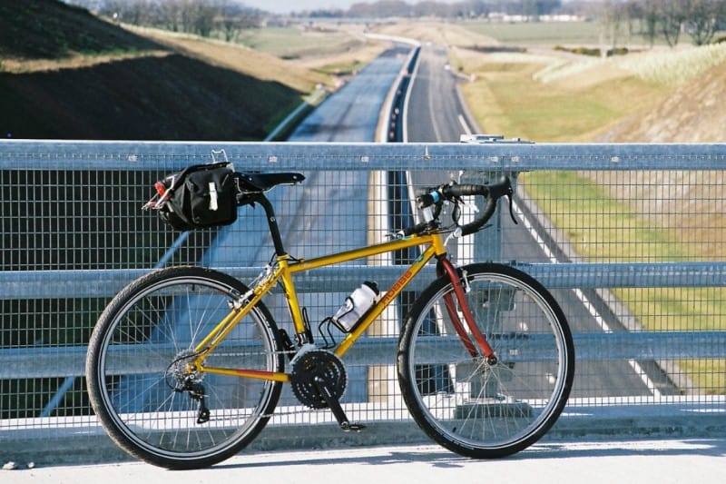 A bicycle is standing near the fence of the bridge